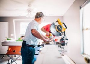 woodworkers cutting a crown molding with a miter saw